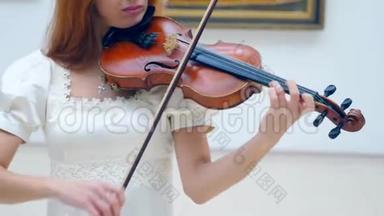 穿着白色衣服的女小提琴手在演奏乐器